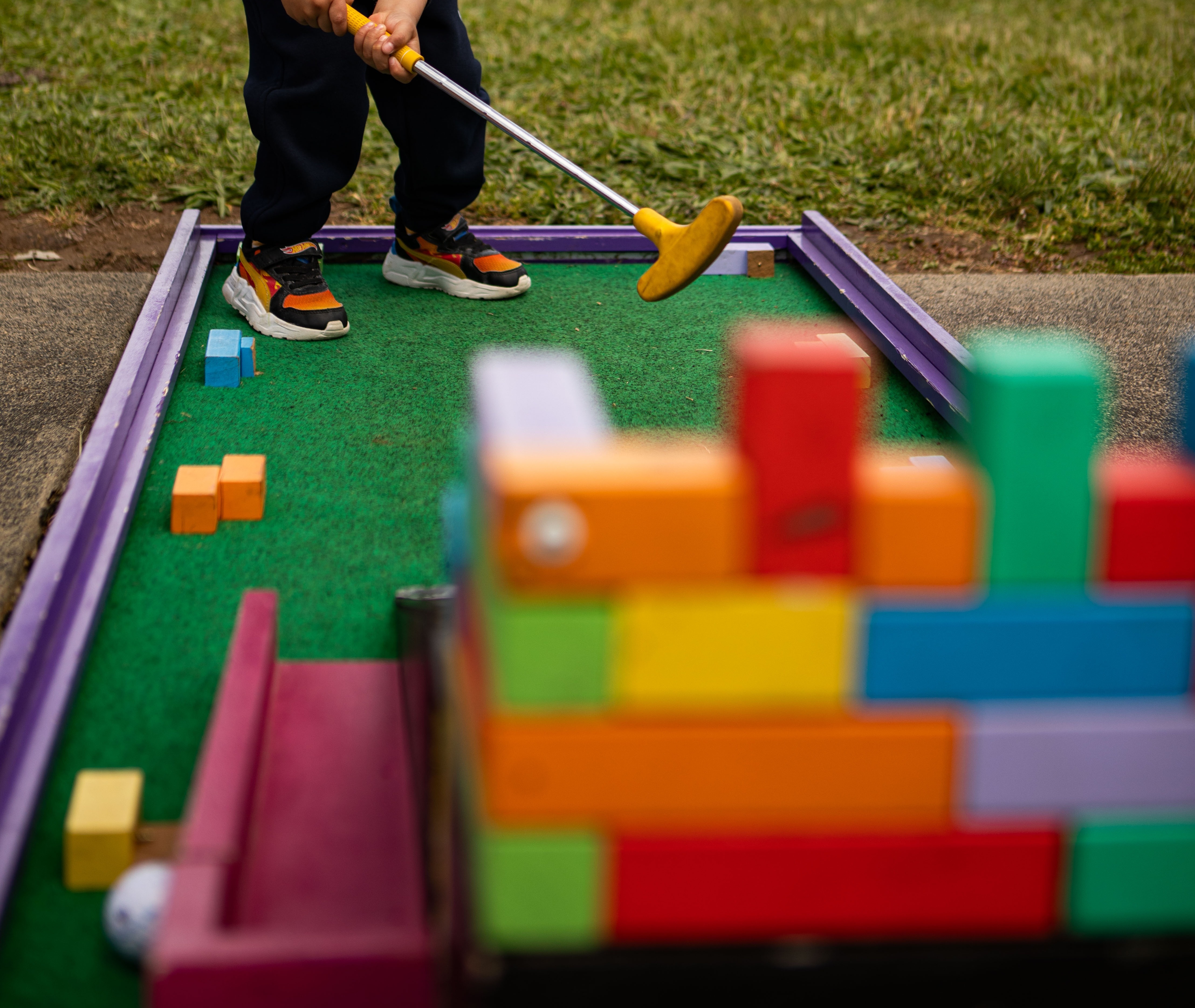 Young child focused on a putt at a mini golf party